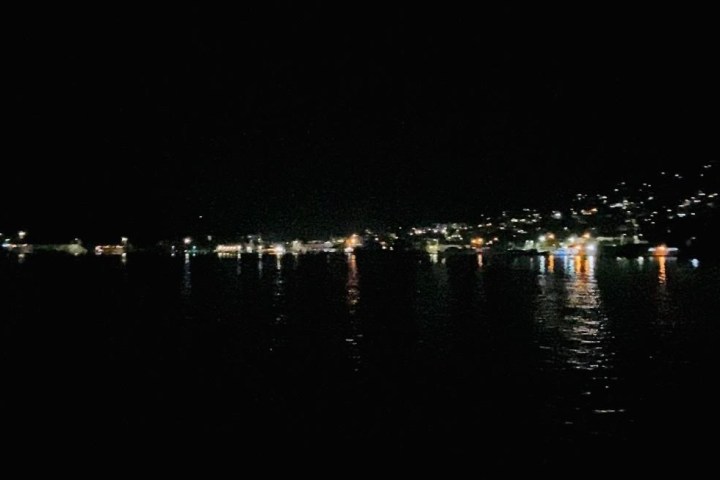 Night city lights reflected on calm waterfront.