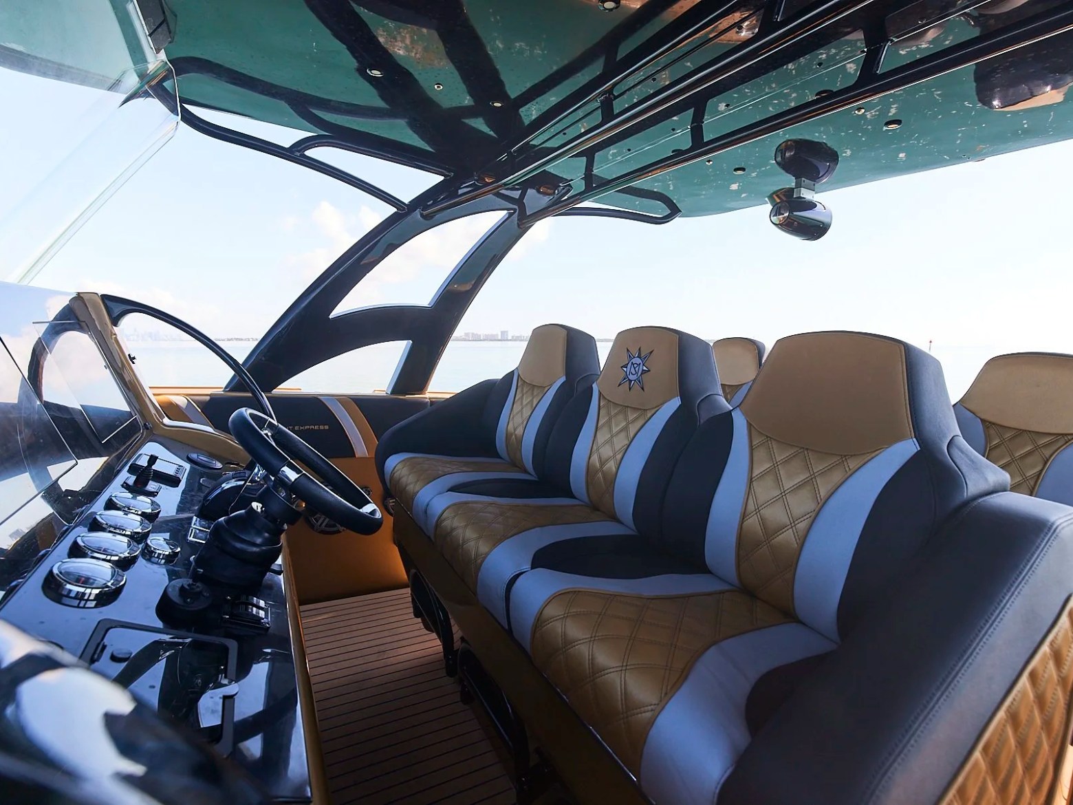 Luxurious yacht interior with brown and white cushioned seats and a modern cockpit.